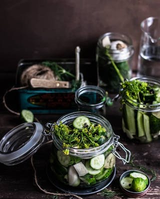 Gurkenscheiben mit Senfblüten und Körnern in Einmachglas